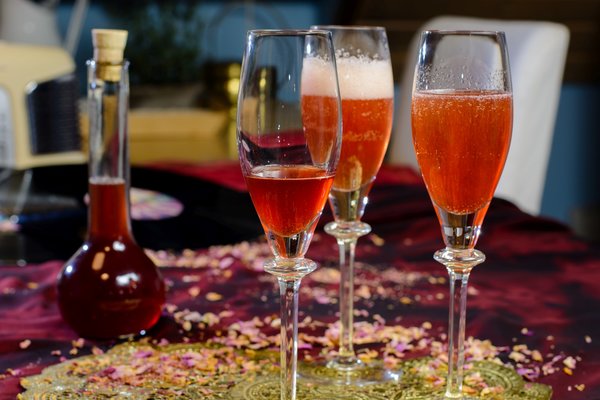 Rosenblütensirup in Sektgläsern auf Tisch