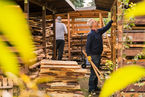 Mann sortiert Zirbenholz in Holzunterstände
